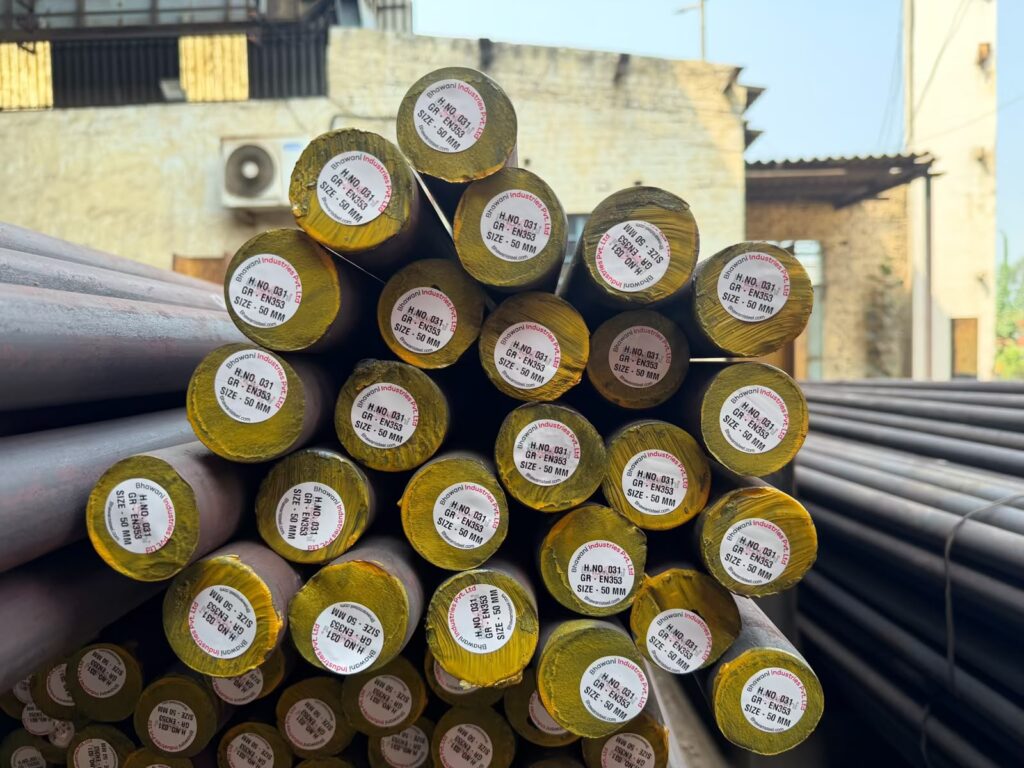 Stacked round steel bars with yellow-painted ends and heat-number tags