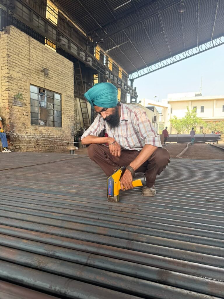Inspector verifying bar grade with a handheld analyser